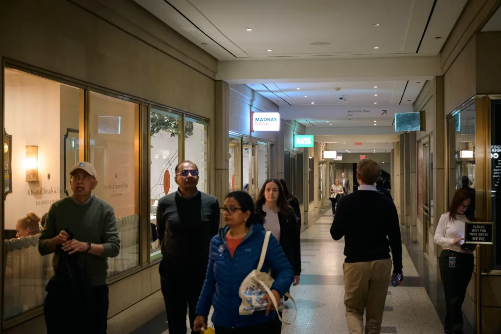 People walking past Madras Dosa restaurant in the concourse at 30 Rockefeller Center, Manhattan.