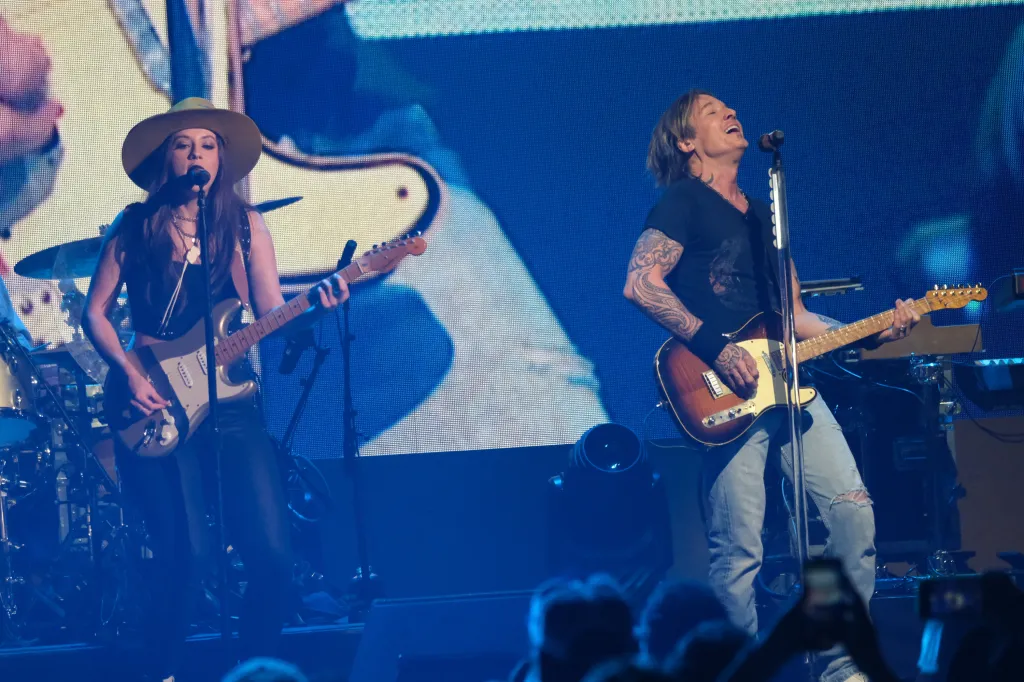 Maggie Baugh and Keith Urban performing on stage.