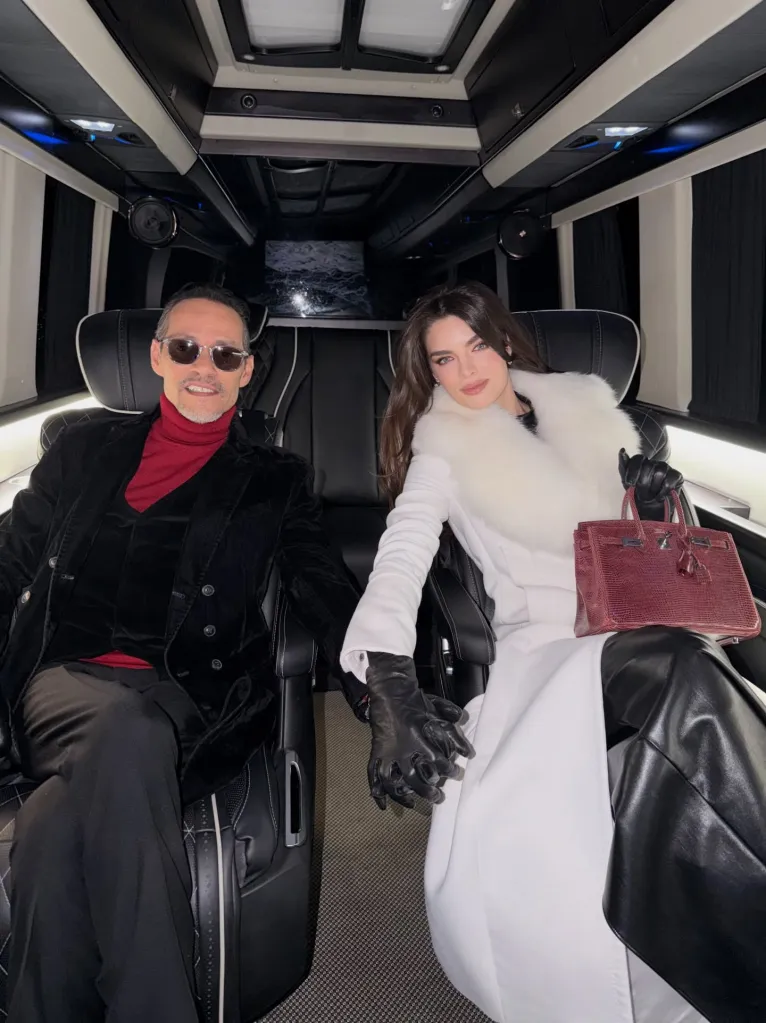 Marc Anthony and Nadia Ferreira holding hands in a car.