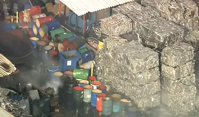 Propane tanks and compressed metal blocks at a scrap yard.