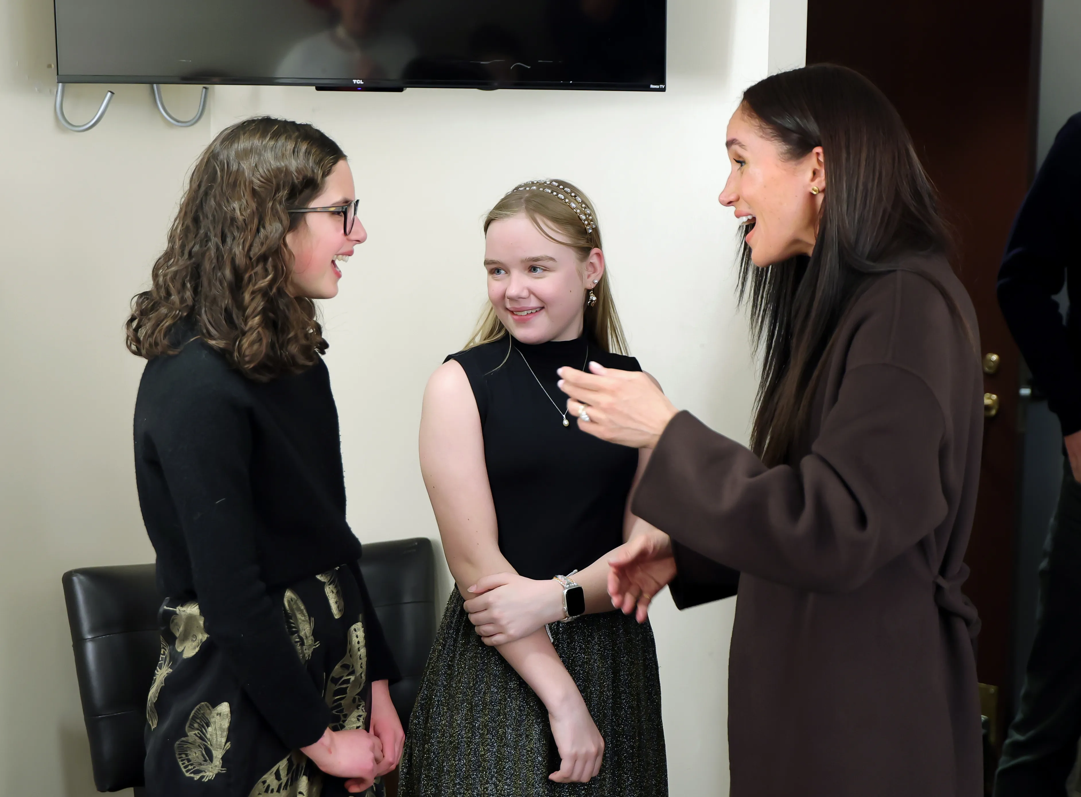 Meghan, Duchess of Sussex, speaks with two young women at the premiere of 