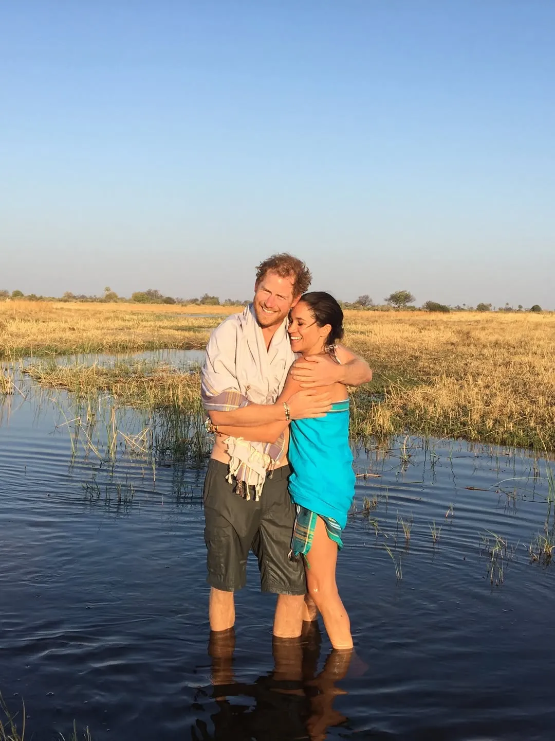 Meghan Markle and Prince Harry embracing in a pond.