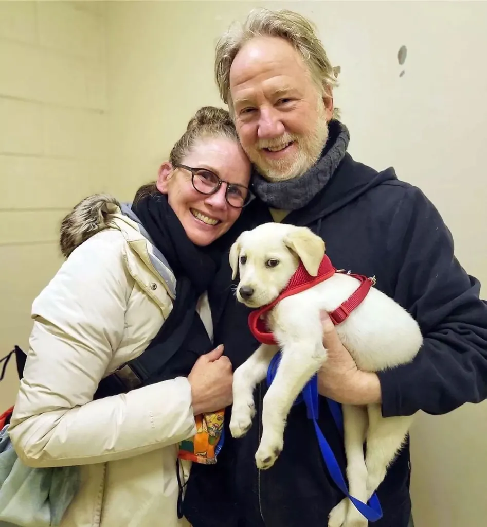 Melissa Gilbert and Timothy Busfield pose with their dog. 