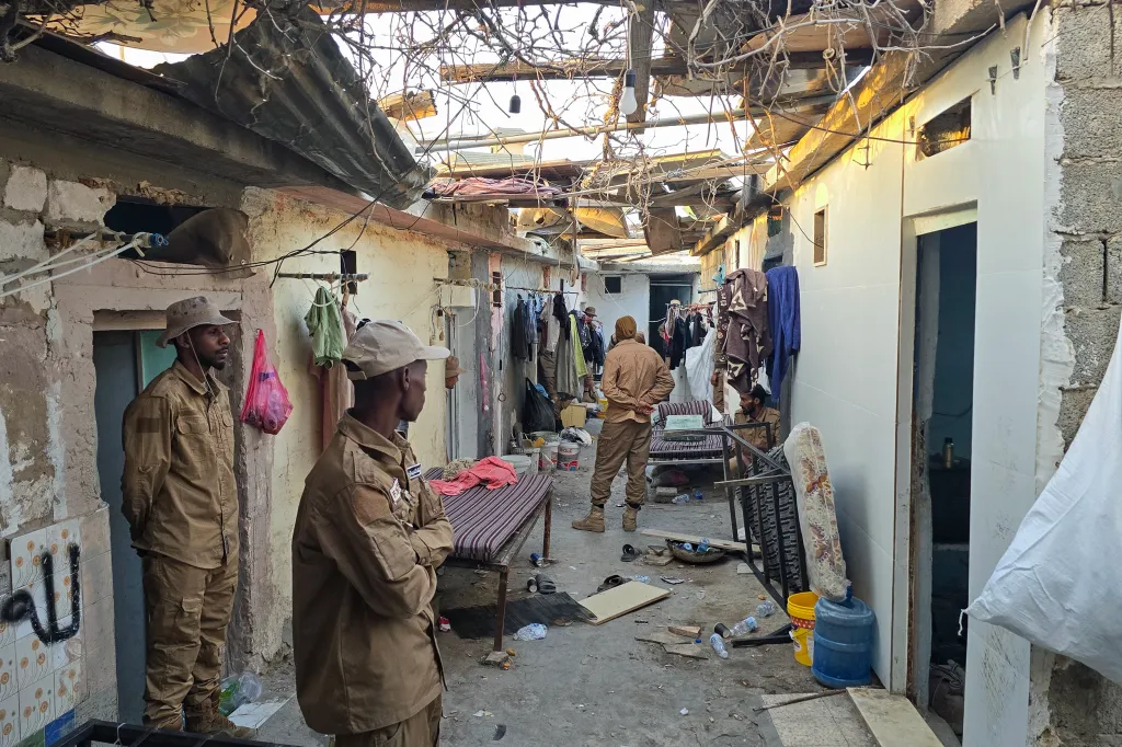 Members of Libya's Anti-Illegal Immigration Agency conduct a raid in an unregistered migrant housing unit in Tripoli.