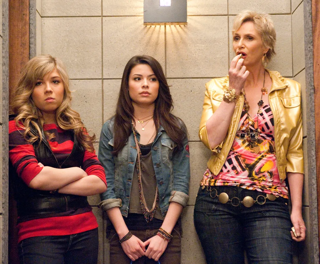 Jennette McCurdy, Miranda Cosgrove, and Jane Lynch standing against a wall.