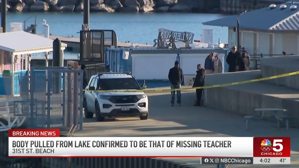 Police vehicles and personnel near Lake Michigan, cordoned off by yellow tape.