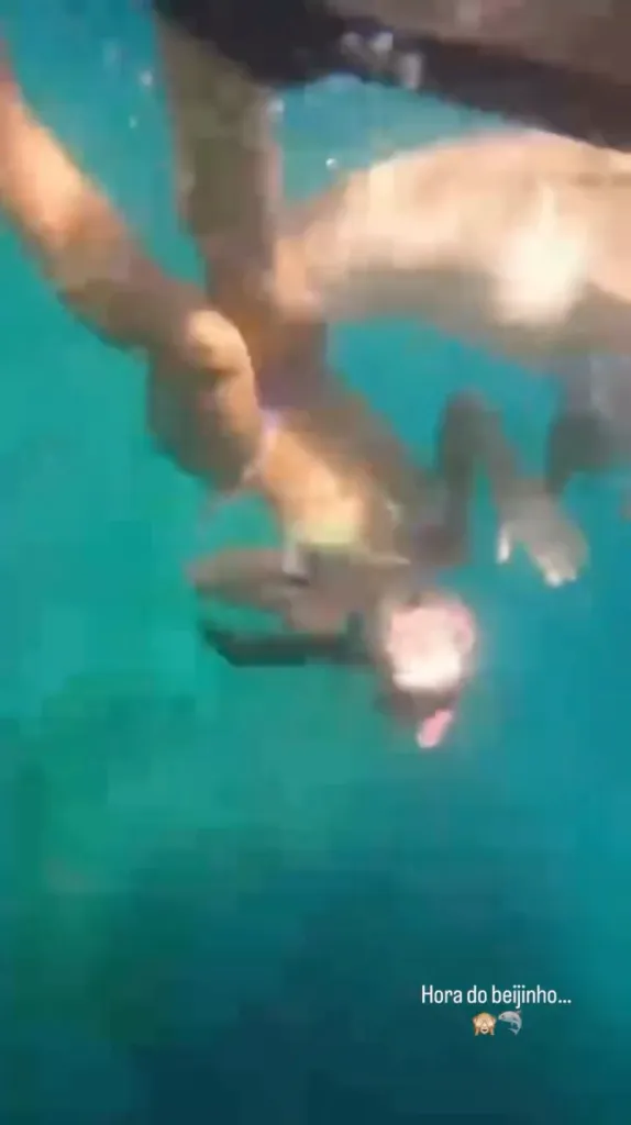 Underwater photo of a female snorkeler being attacked and bitten on the leg by a shark.
