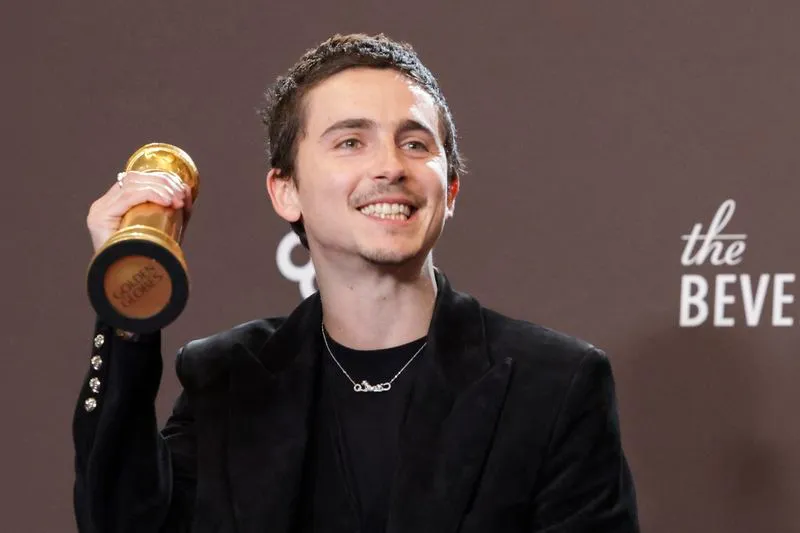 Timothée Chalamet posing with his Golden Globe award for Best Performance by a Male Actor in a Motion Picture - Musical or Comedy for