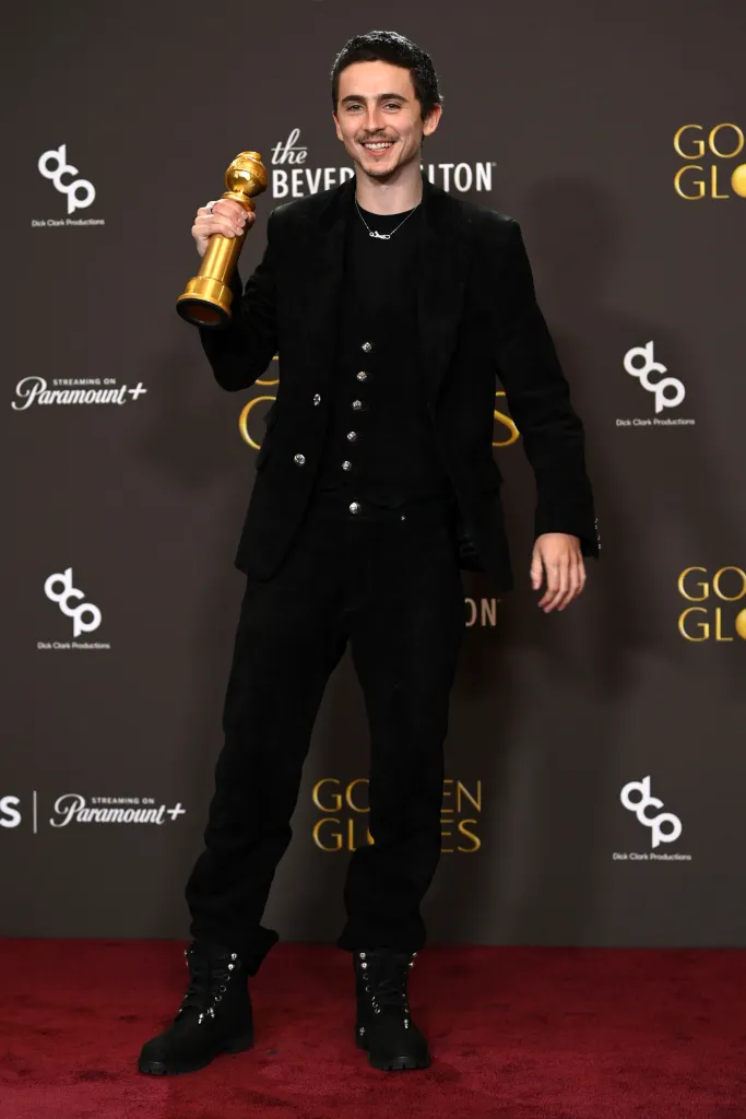 Timothée Chalamet posing with his Golden Globe Award.