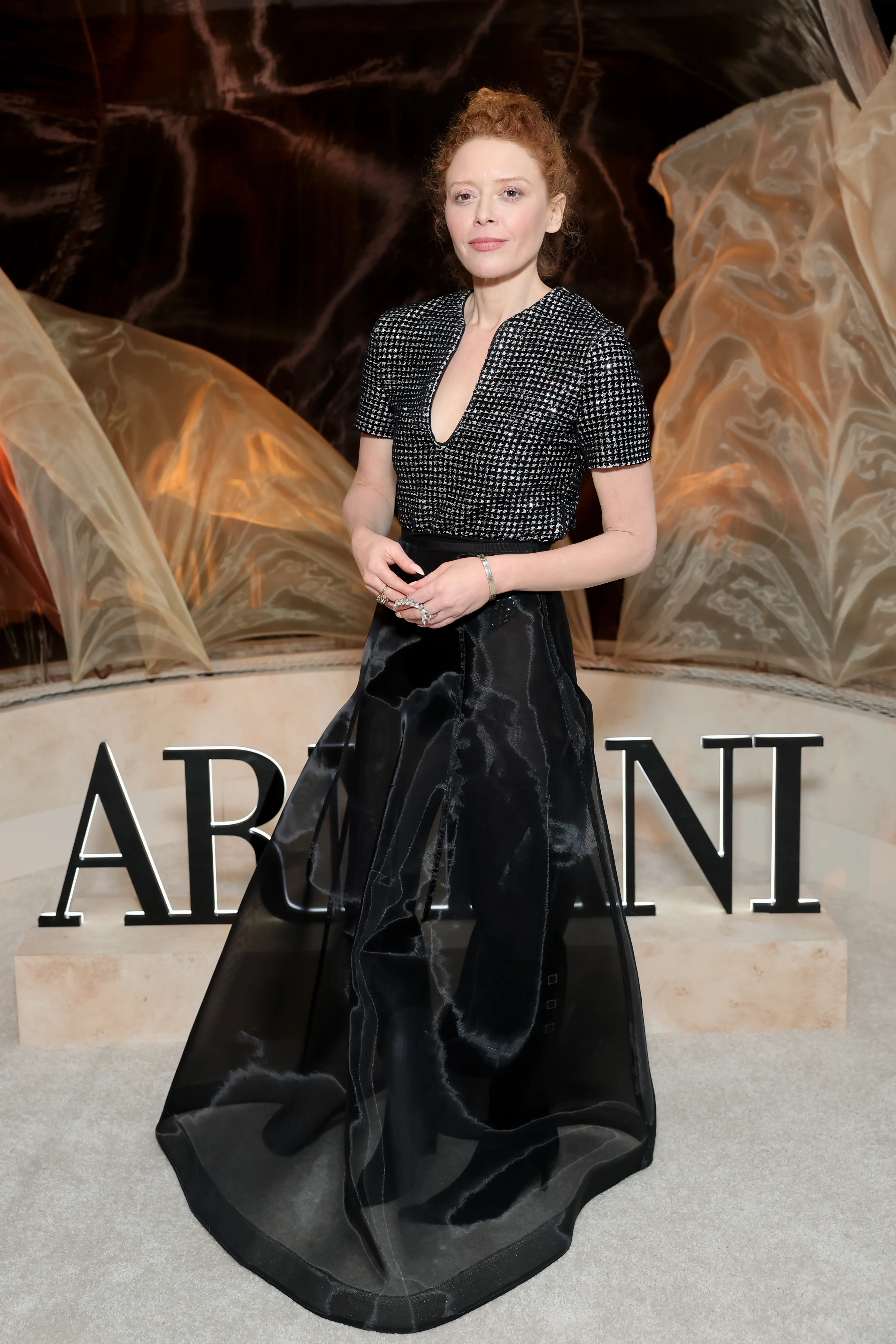Natasha Lyonne in a sparkling top and flowing black skirt at an Armani Beauty event.