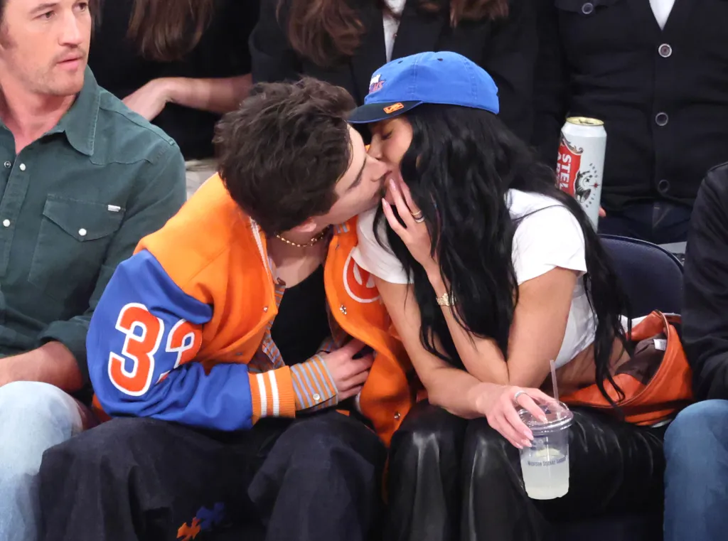 Timothée Chalamet and Kylie Jenner share a kiss while sitting courtside at an NBA game.