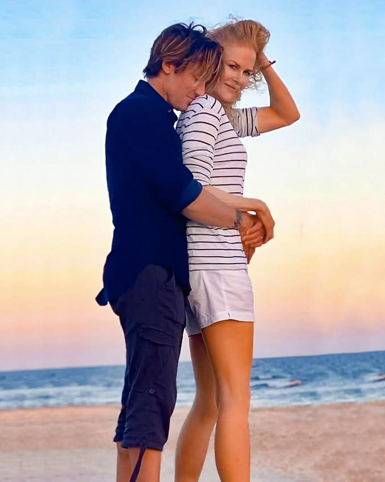 Nicole Kidman and Keith Urban embracing on a beach.