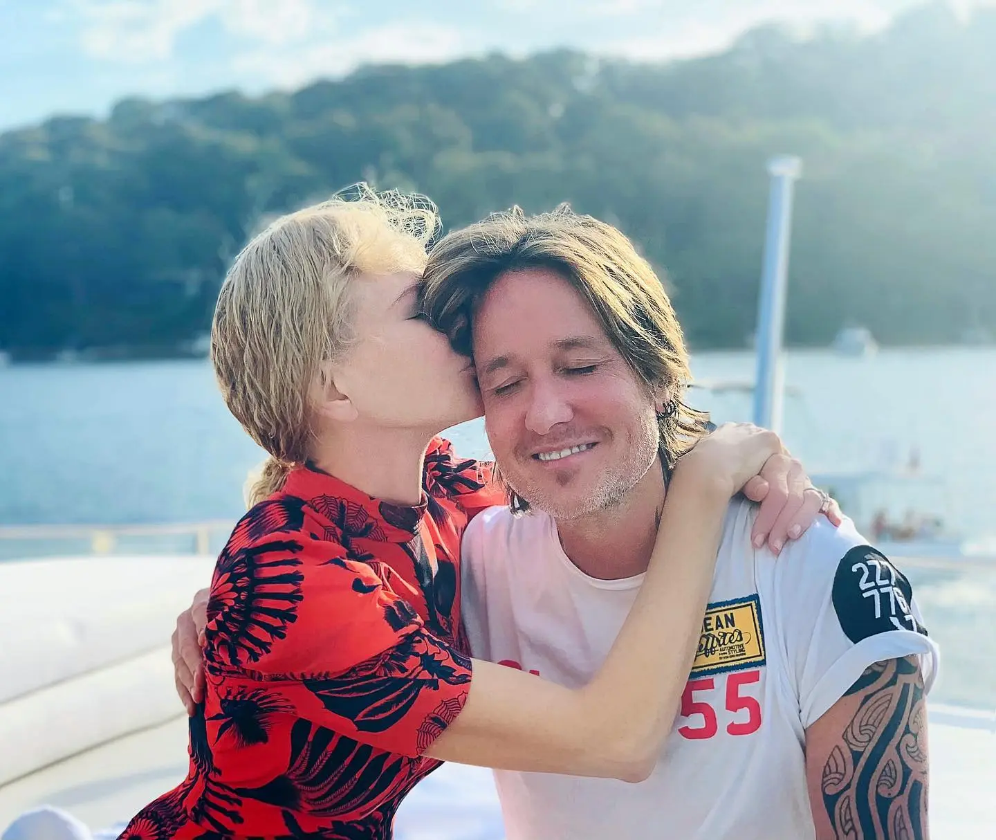 Nicole Kidman kissing Keith Urban on the cheek while on a boat.