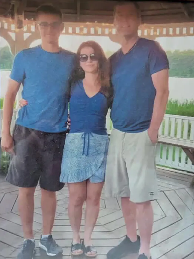 Nikita Casap, Tatiana Casap and Donald Mayer standing in blue shirts under a gazebo.