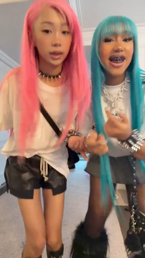 North West and a friend showing off punk-rock inspired outfits, piercings, and black-tinted teeth.