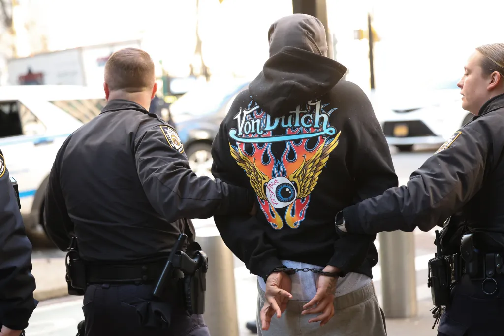 Two police officers escorting a suspect in handcuffs.