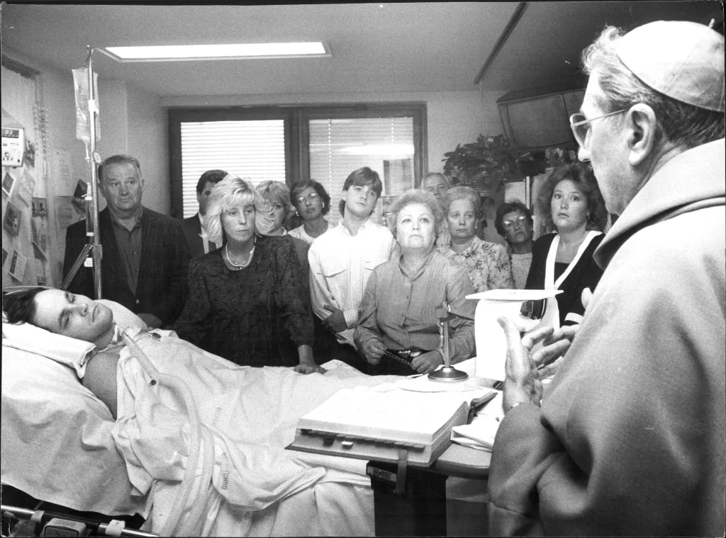 Archbishop John J. O' Connor speaking to people gathered around the bedside of wounded NYC Police Officer Steven McDonald.