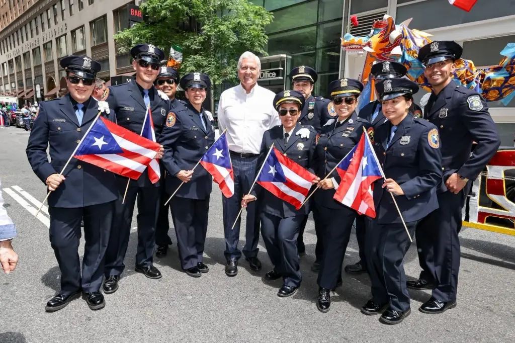 Nine police officers and one civilian posing with Puerto Rican flags.