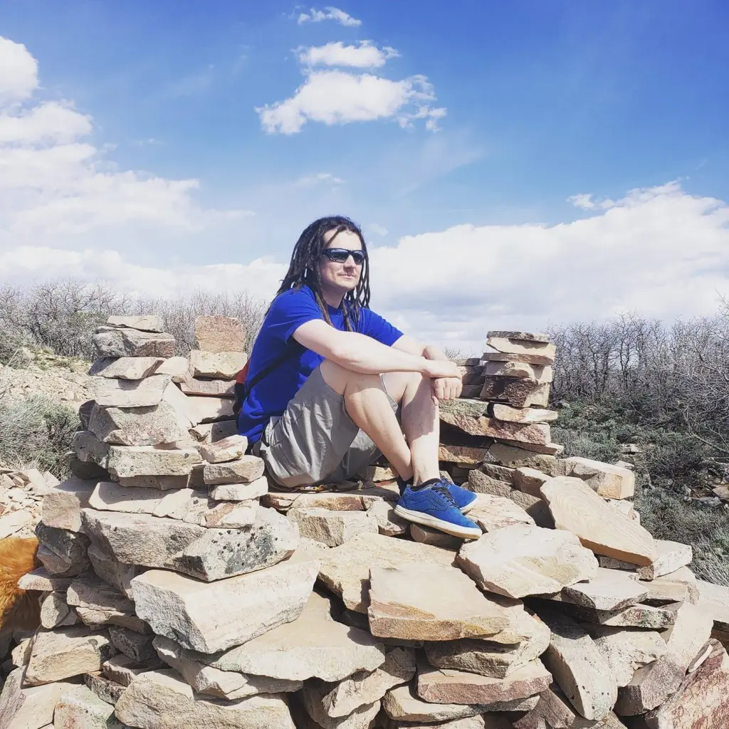 Kyler Lydens Efinger sitting on a rock pile.
