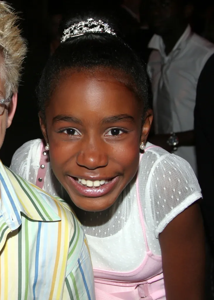 Kianna Underwood smiling with a tiara and pearl earrings.