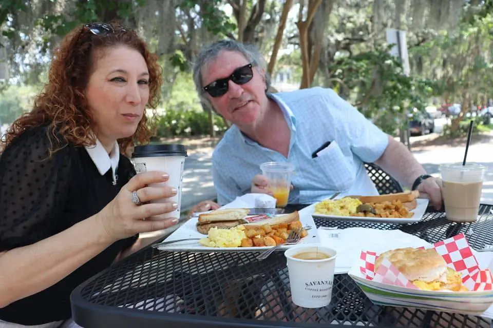 Two people eating breakfast at an outdoor cafe.