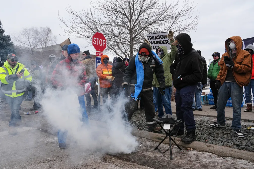 People cover tear gas deployed by federal immigration officers outside Bishop Henry Whipple Federal Building, on Jan. 15, 2026, in Minneapolis.