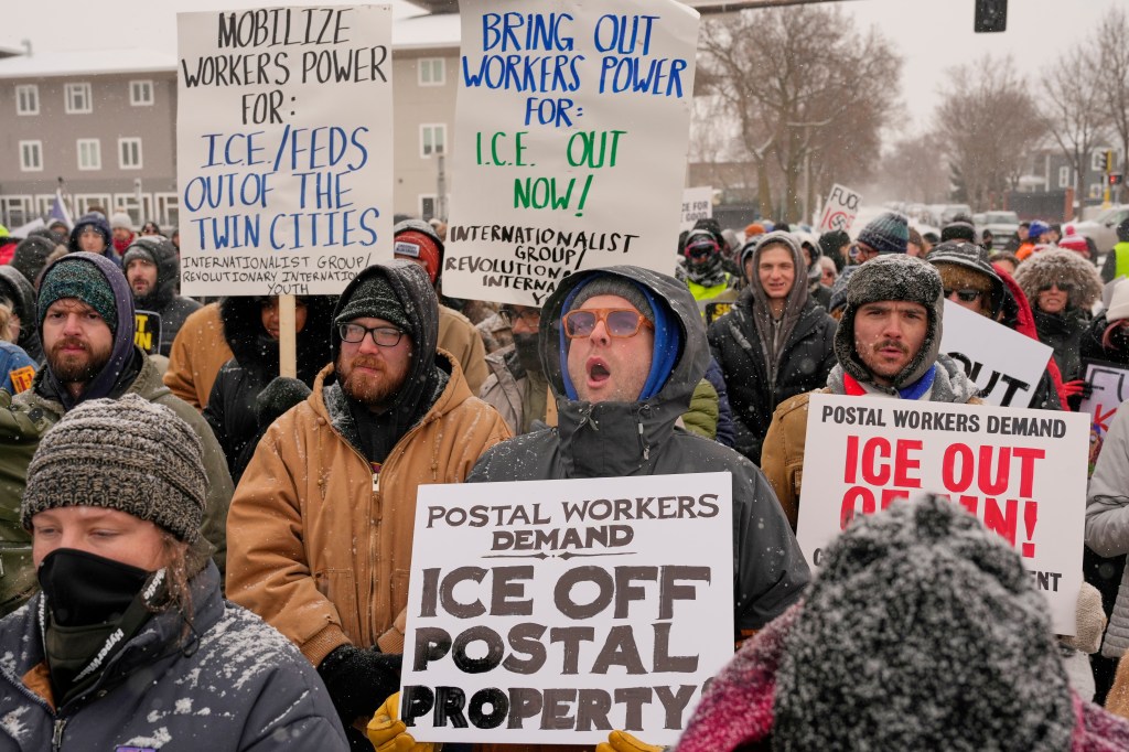 People march and gather near the post office during a protest, Sunday, Jan. 18, 2026, in Minneapolis.