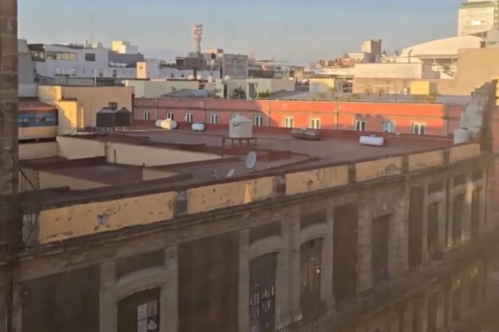 People stand outside a building in Mexico City during an earthquake.