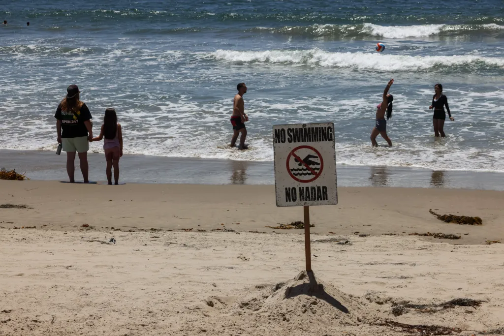 People in the ocean at Santa Monica Pier despite 