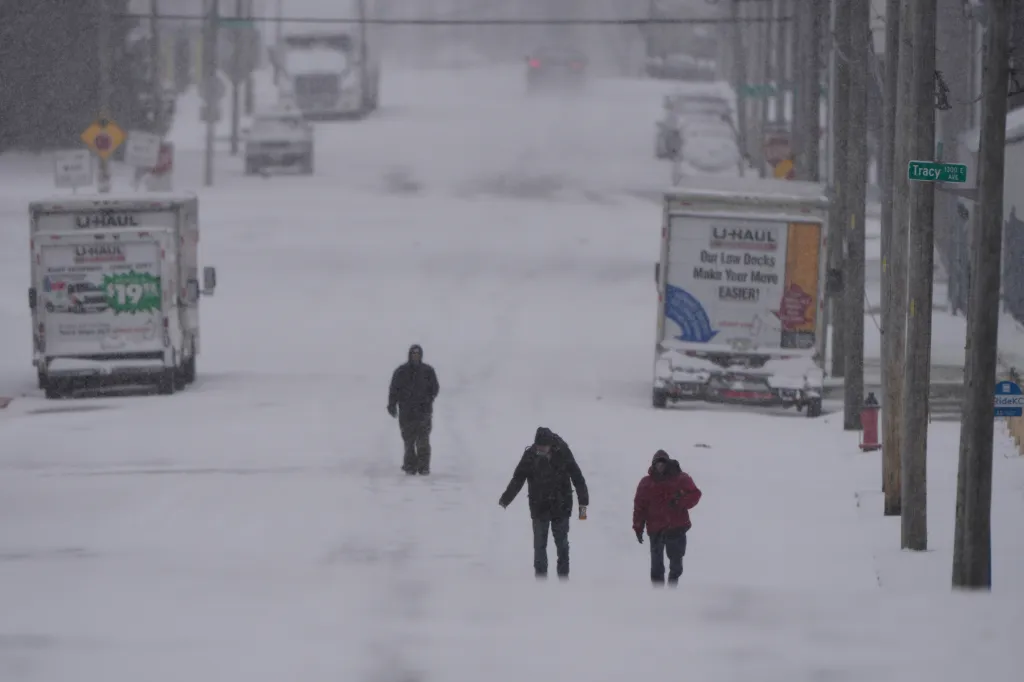 People walk on a snow covered street in Kansas City, Missouri, on Jan. 24, 2026.