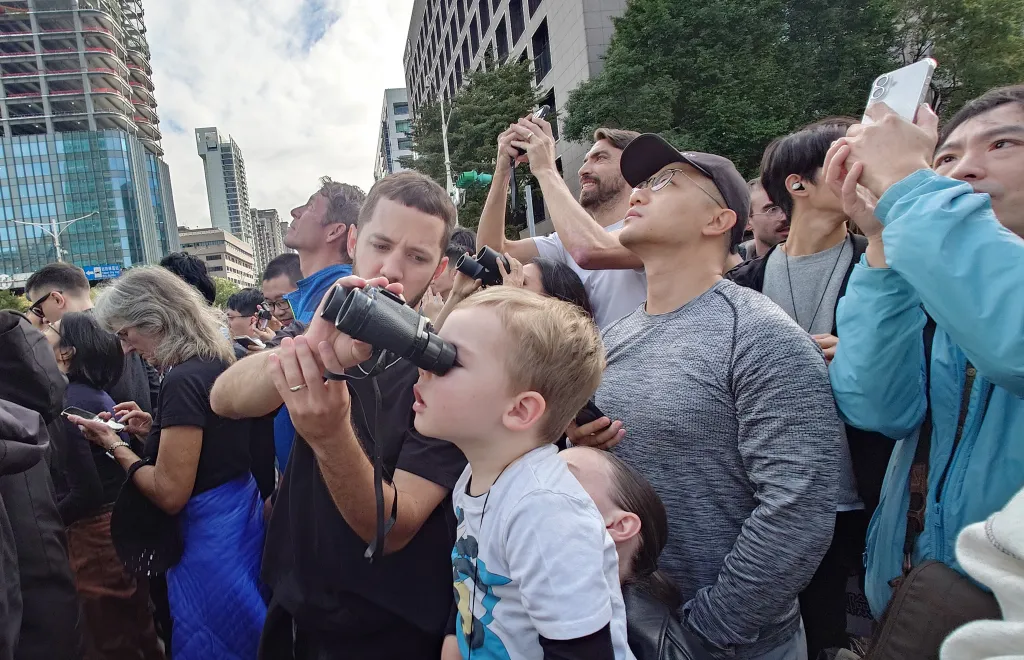 People watch rock climber Alex Honnold perform a free solo climb of the Taipei 101 skyscraper in Taipei.