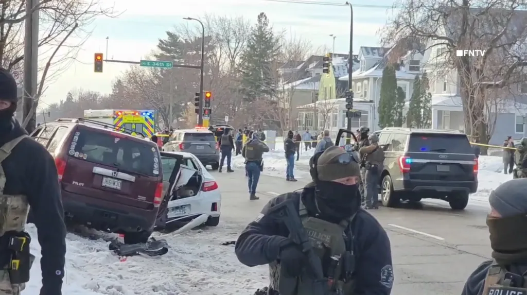 Federal agents and an ambulance respond to a scene with two crashed cars in Minneapolis.