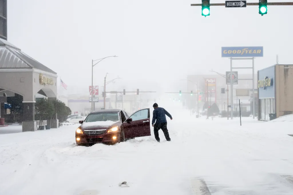 A person tries to get their car unstuck from the snow in Little Rock, Arkansas, on Jan. 24, 2026.