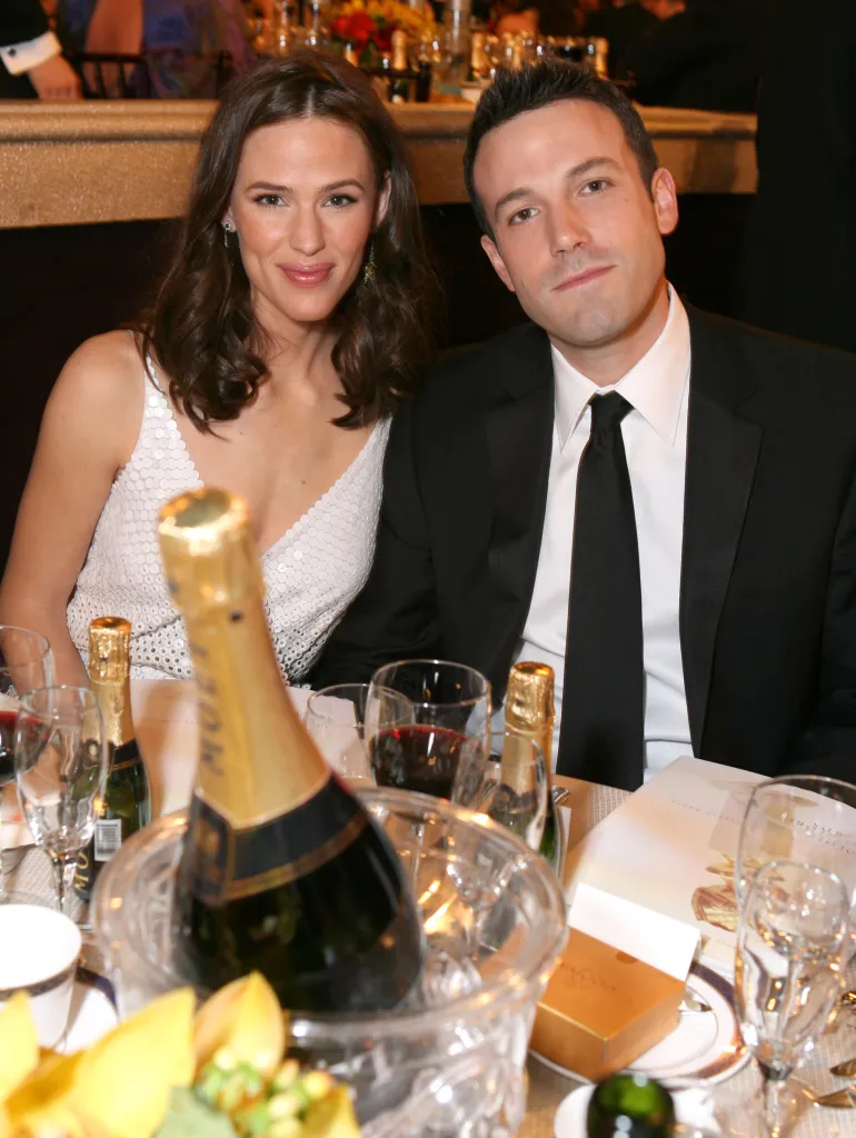 Jennifer Garner and Ben Affleck sitting at a table with champagne.
