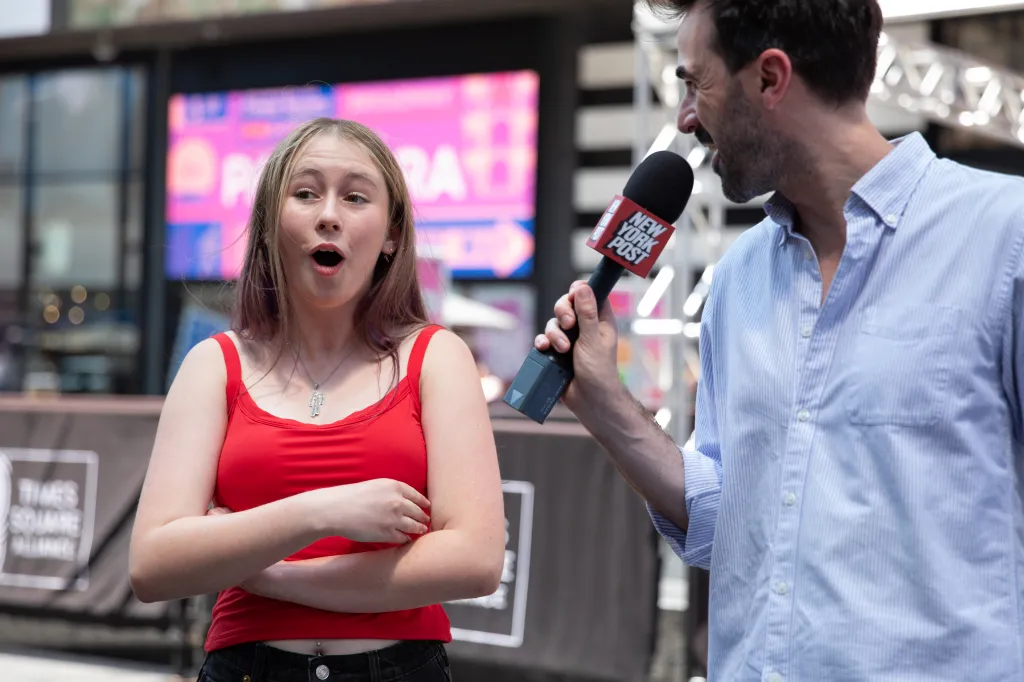 A reporter interviews a young woman in Times Square.