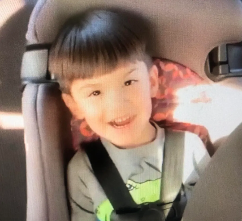 Aiden Leos smiling while strapped into a car seat.