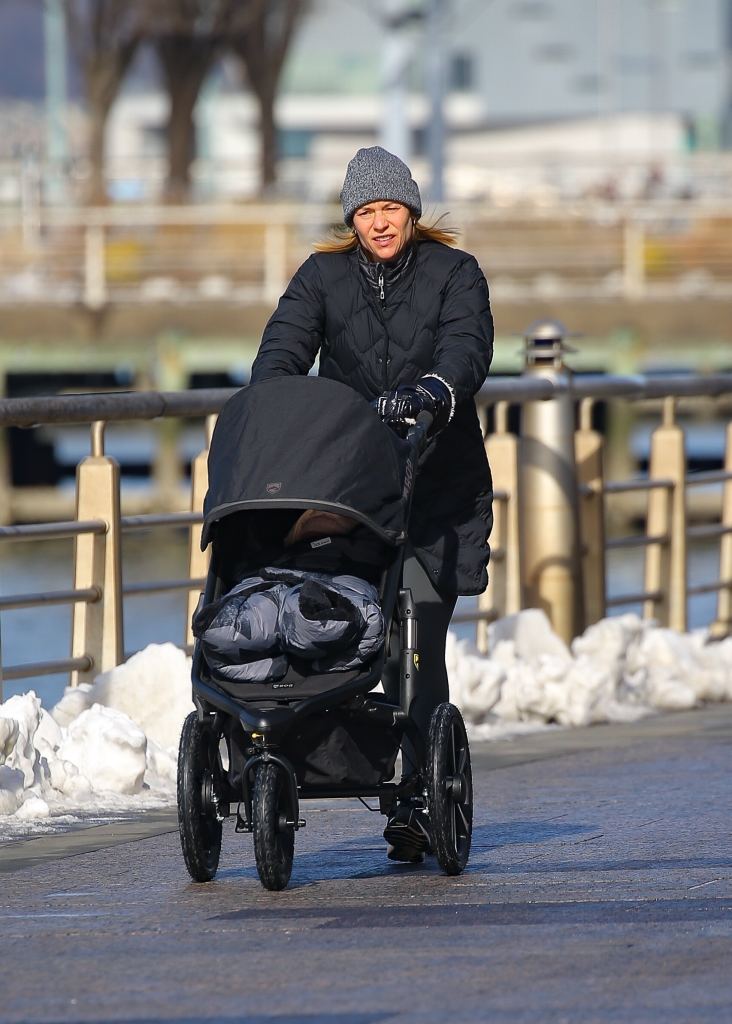 Claire Danes pushing a baby stroller along the Hudson River on a sunny day.