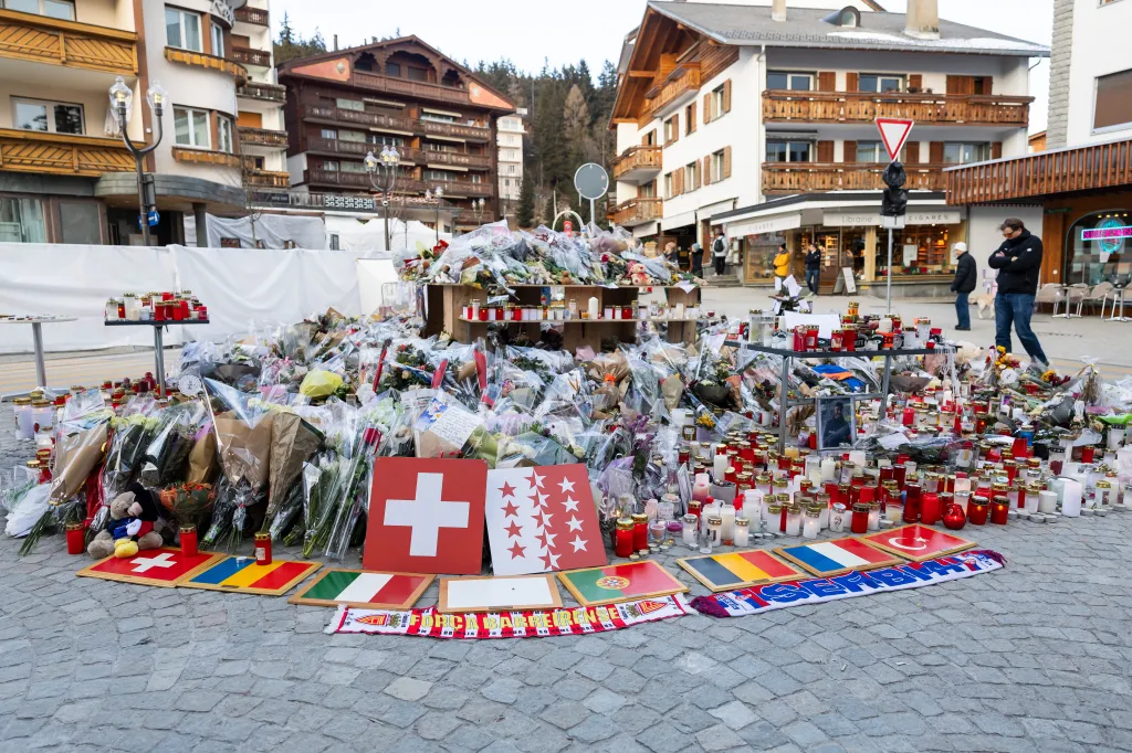 Flags and flowers are placed at a memorial in Crans-Montana on Jan. 6, 2026.