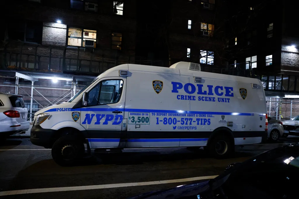 NYPD Crime Scene Unit van parked outside an apartment building at night.