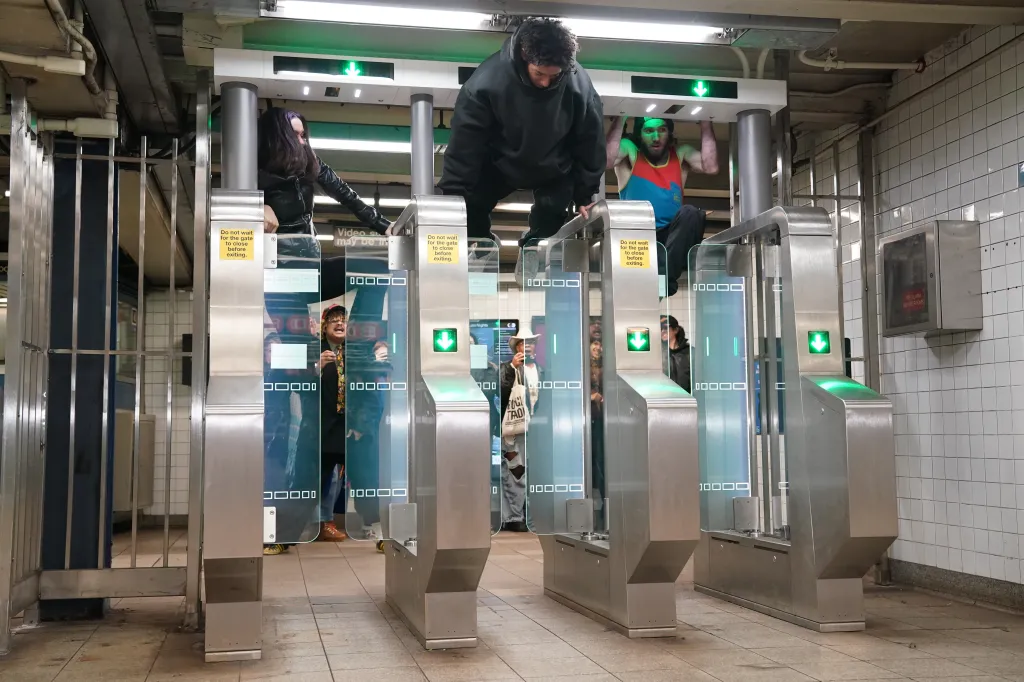 The group climbs over the turnstiles.