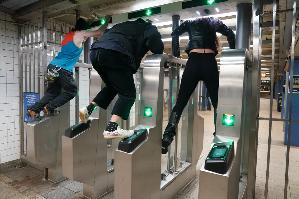 The group climbs over the turnstiles.