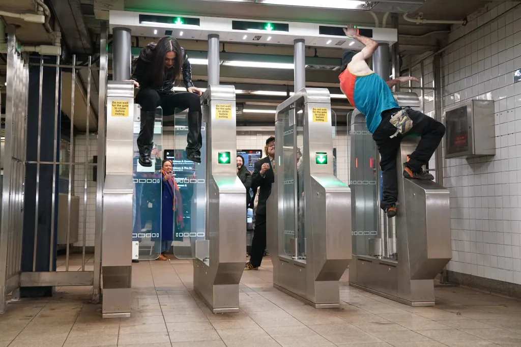 The group climbs over the turnstiles.