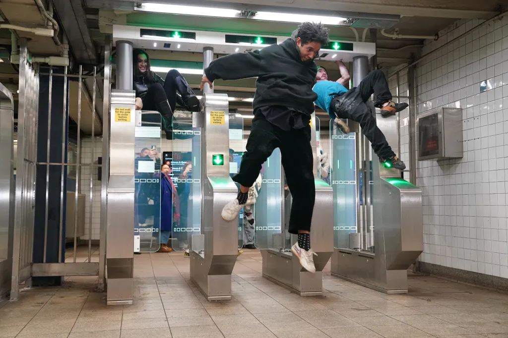 The group climbs over the turnstiles. 