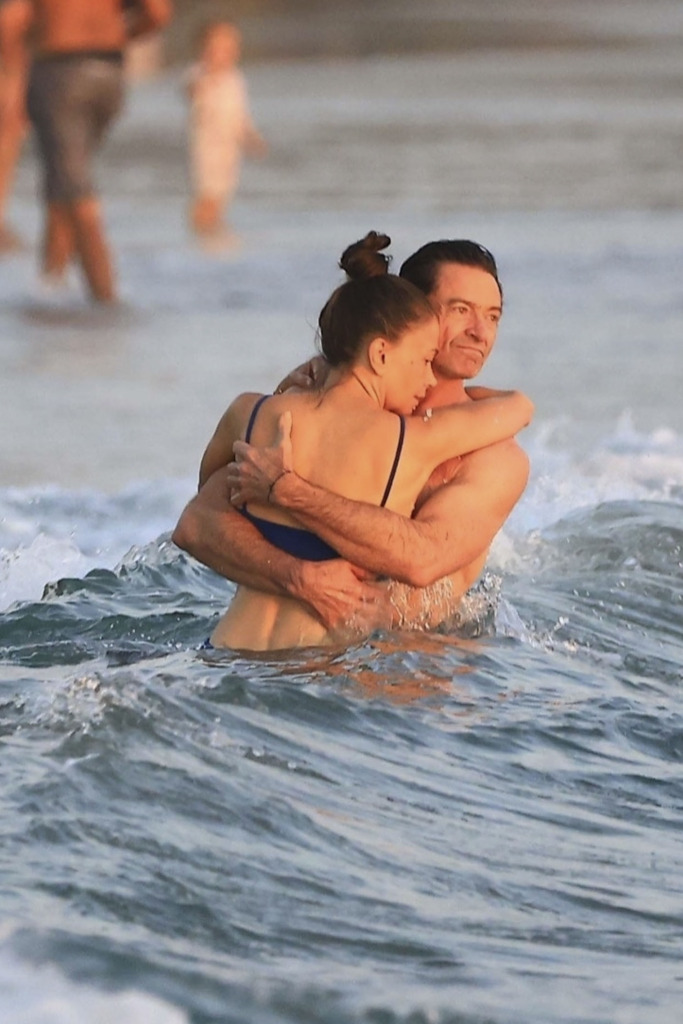 Hugh Jackman and Sutton Foster embracing in the ocean.