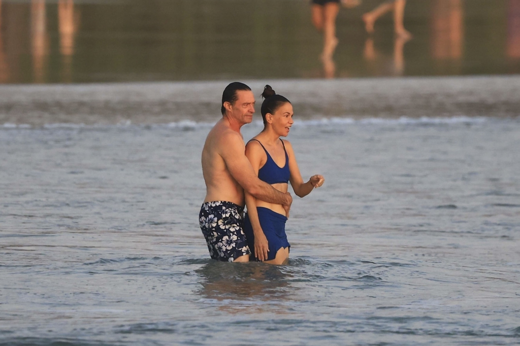 Hugh Jackman and Sutton Foster wading in the ocean.