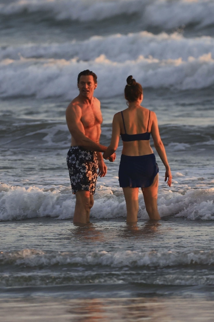 Hugh Jackman and Sutton Foster hold hands in the ocean during sunset in Costa Rica.