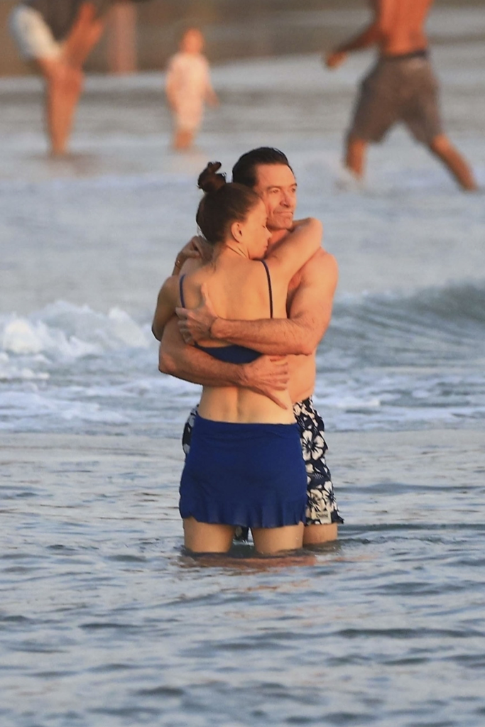 Hugh Jackman and Sutton Foster embracing in the ocean.