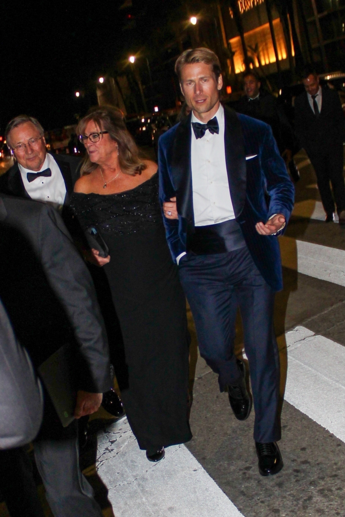 Glen Powell, in a blue velvet tuxedo, with his mom Cyndy Powell, in a black off-the-shoulder gown, at the Golden Globes.