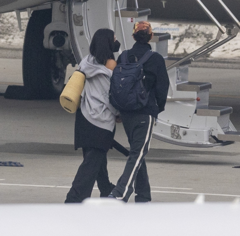 Kylie Jenner and Timothée Chalamet boarding a private jet, walking hand-in-hand.