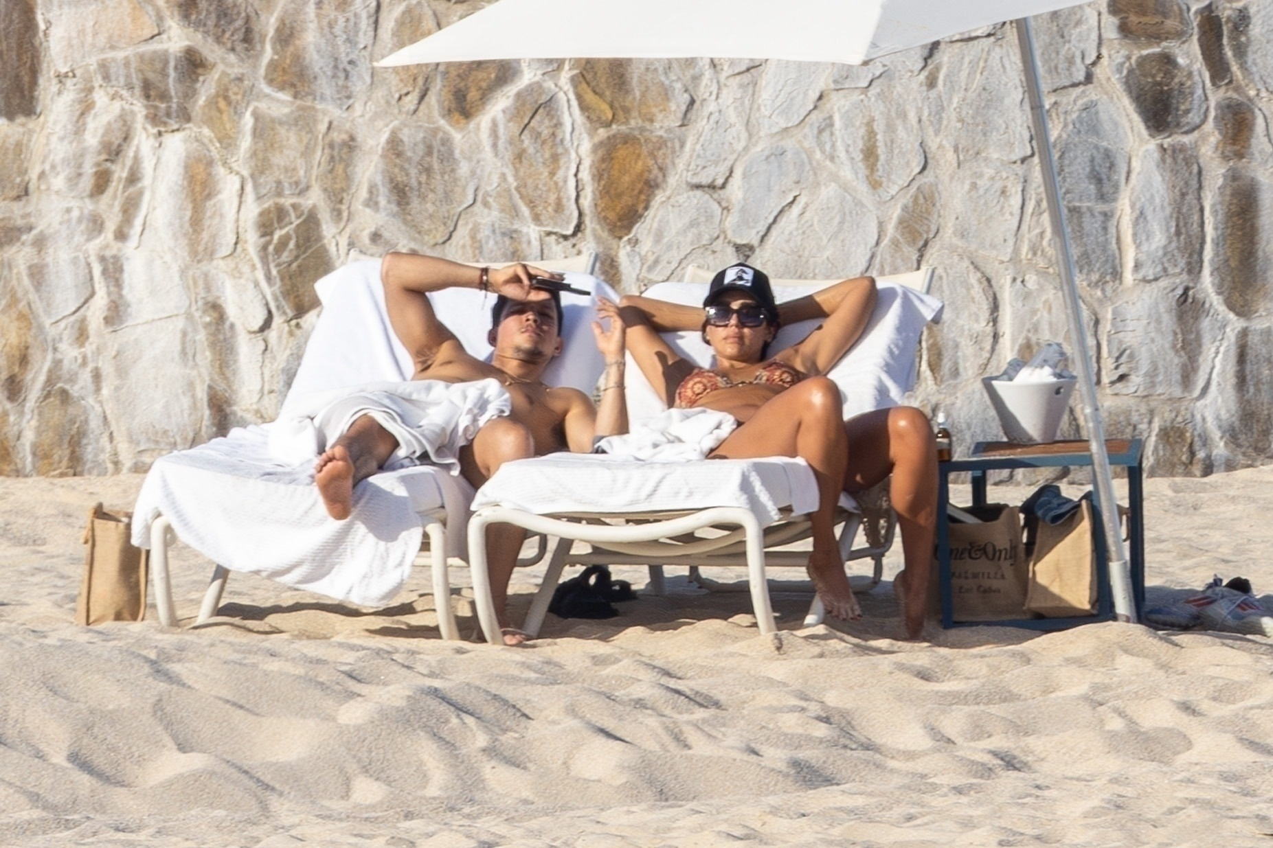 Jessica Alba and Danny Ramirez relaxing on beach chairs in Cabo.